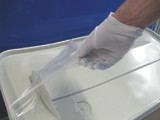 Abziehen der im Fraunhofer IFAM entwickelten FlexPLAS®-Trennfolie von einem Faserverbundbauteil, das mit einem Gelcoat in der Form lackiert wurde.
