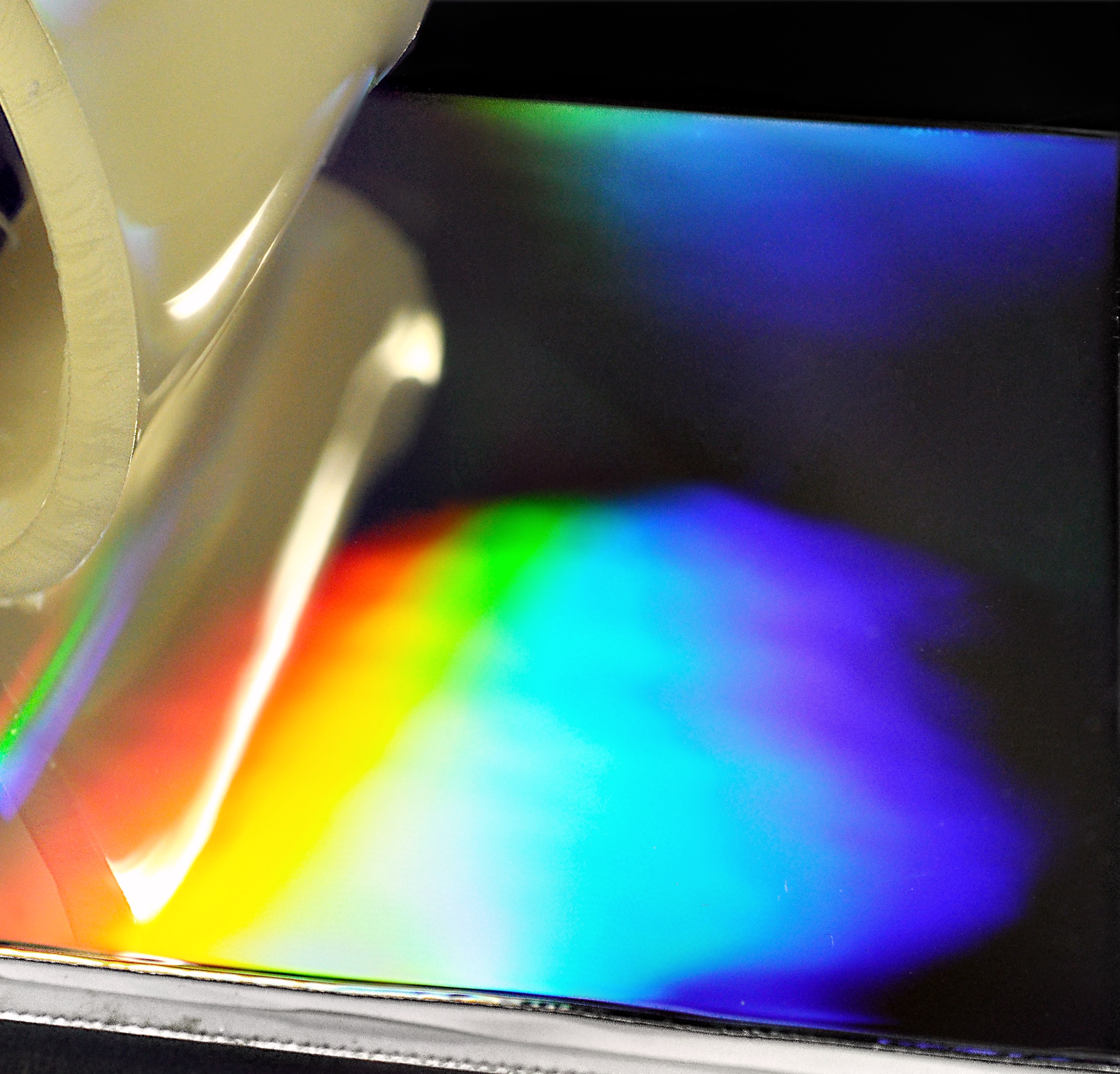 PUR wird von einer permanent beschichteten, nanostrukturierten Metalloberfläche sauber abgelöst. Durch die Nanostruktur kommt es im Bild zur Lichtbeugung und damit zur Farbgebung.
