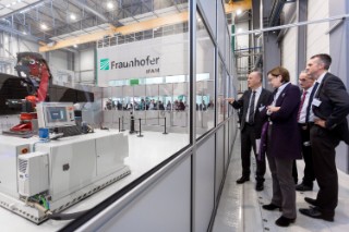 Dr. Dirk Niermann, Abteilungsleiter Automatisierung und Produktionstechnik, Fraunhofer IFAM, Ingelore Hering, Abteilungsleiterin Industrie und Maritime Wirtschaft, Niedersächsisches Ministerium für Wirtschaft, Arbeit und Verkehr, Prof. Dr. Bernd Mayer, Institutsleiter, Fraunhofer IFAM, und Dr. Alexander Roth, Direktor für Technologiemarketing, Fraunhofer- Gesellschaft, (v.l.n.r.), diskutieren über Einsatzmöglichkeiten des weltweit genauesten Sechs- Achs-Bearbeitungsroboters auf einem eigens entwickelten AGV (Autonomos Transport Vehicle); (© Fraunhofer IFAM).