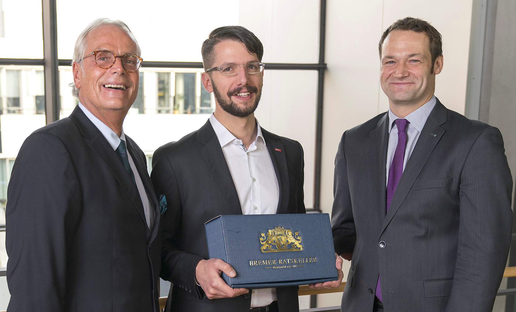 Prof. Dr. Andreas Groß (l.) und Dr. Erik Meiß (r.) ehren Marco Molisse als zehntausendsten Kursteilnehmer des Weiterbildungszentrums Klebtechnik während der 17. Bremer Klebtage