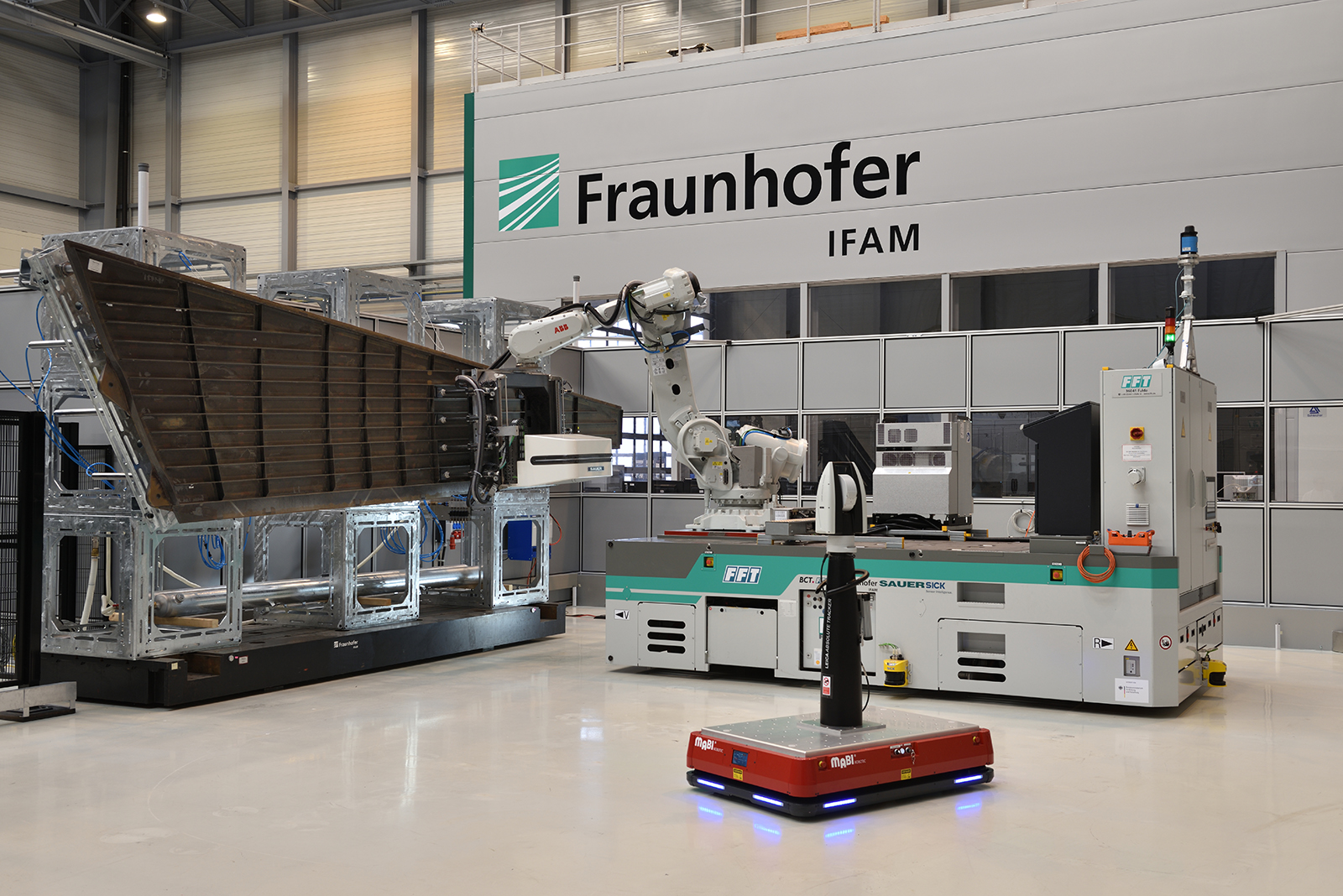 MBFast18-Gesamtanlage mit Mehrachs-Bearbeitungseinheit, Roboter, AGV und mobilem Lasertracker an einer Flugzeugseitenleitwerksschale im Technikum des Fraunhofer IFAM l Stade.