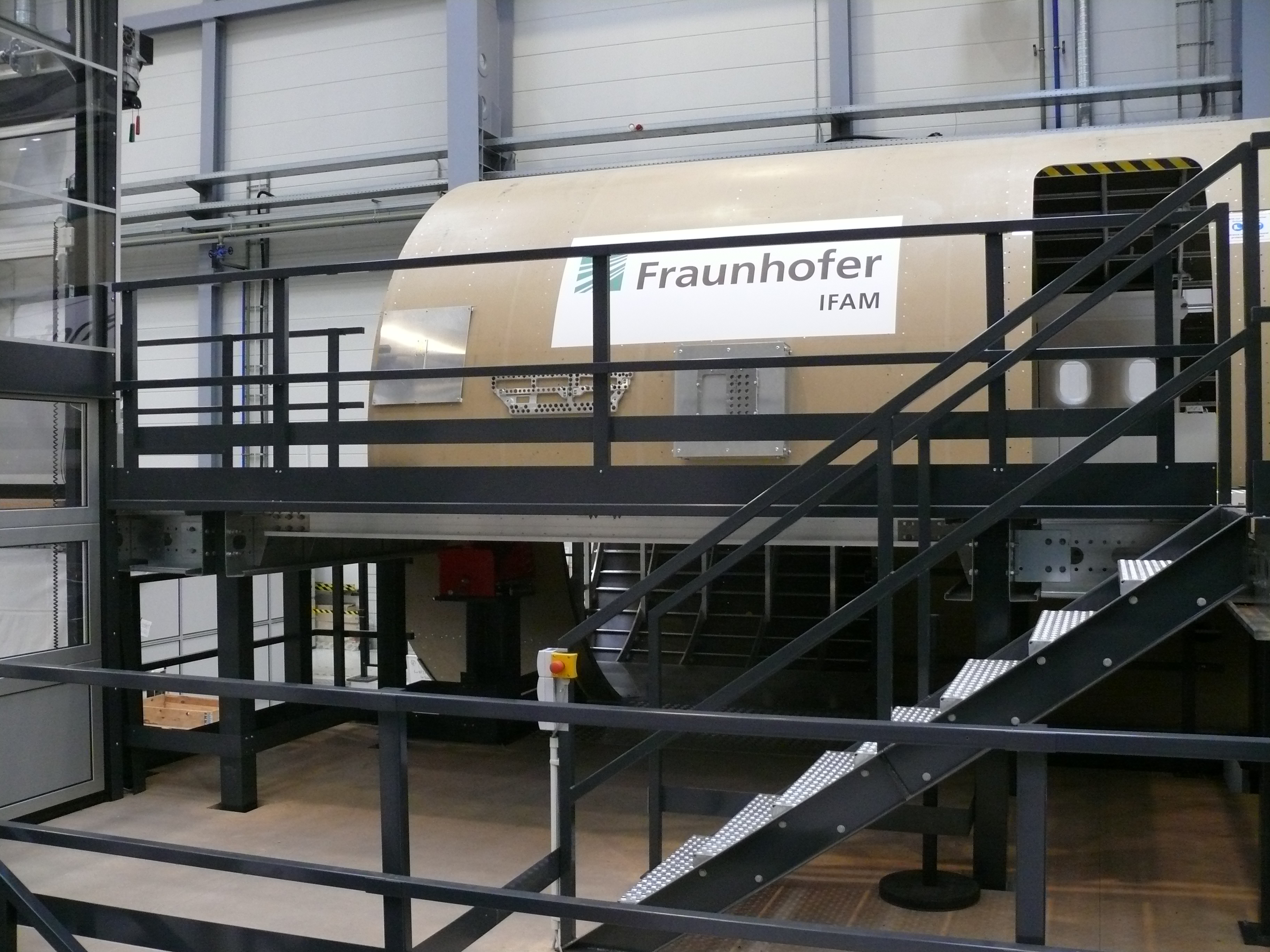 Der für das Projekt Clean Sky 2 – ACCLAIM in Stade entwickelte Flugzeugrumpf-Demonstrator im 1:1-Maßstab mit Plattform und Transportlift (linker Bildrand). Der für das Projekt Clean Sky 2 – ACCLAIM in Stade entwickelte Flugzeugrumpf-Demonstrator im 1:1-Maßstab mit Plattform und Transportlift (linker Bildrand).