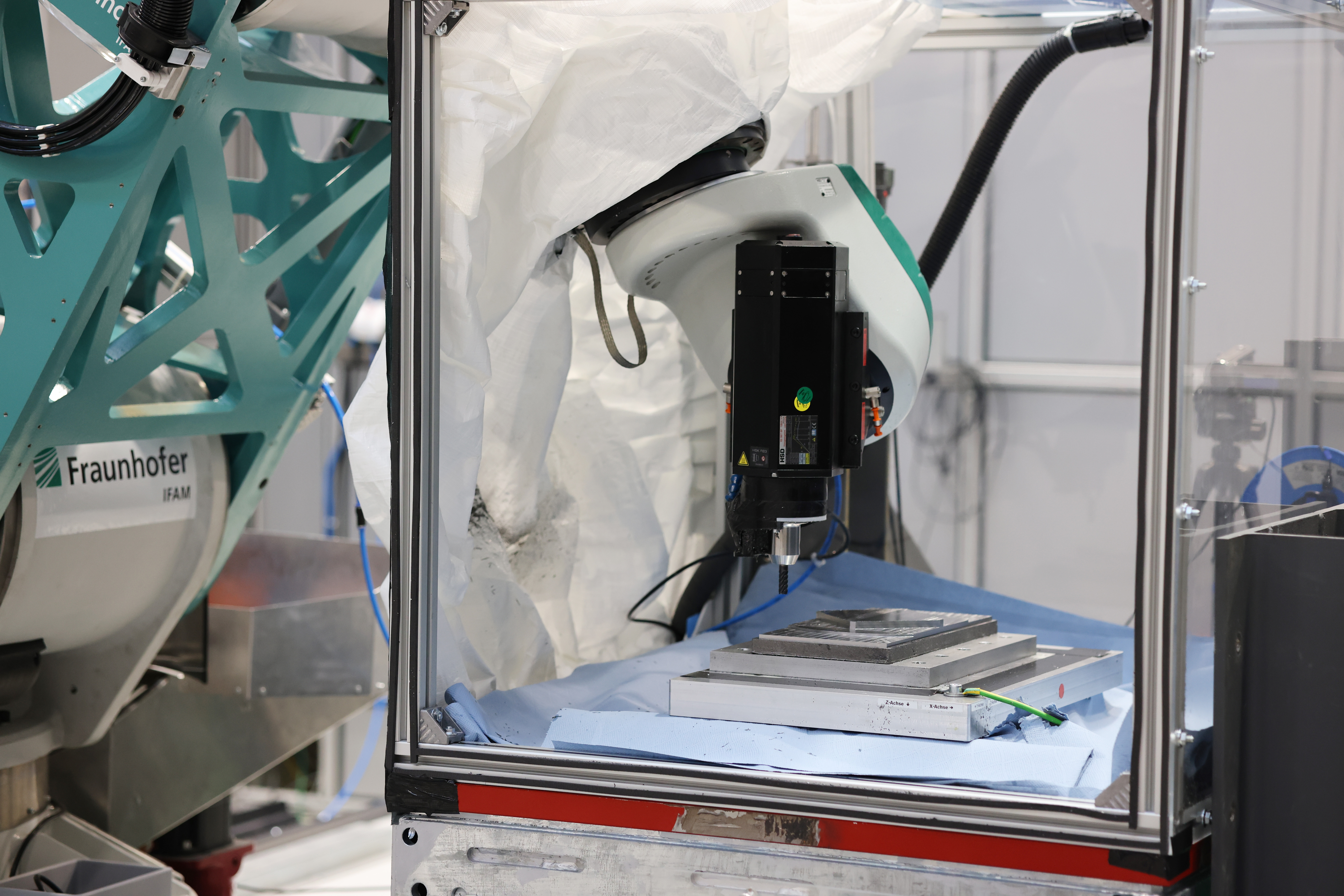 Die »MultiFAL«-Montage-Forschungsplattform mit eingerüsteten thermoplastischen Rumpfschalen des »MFFD« bei der Fraunhofer-Gesellschaft in Stade. Gut erkennbar sind die gelben Hexapod-Roboter zum Halten und hochpräzisen Einstellen von Form sowie Lage der Oberschale.