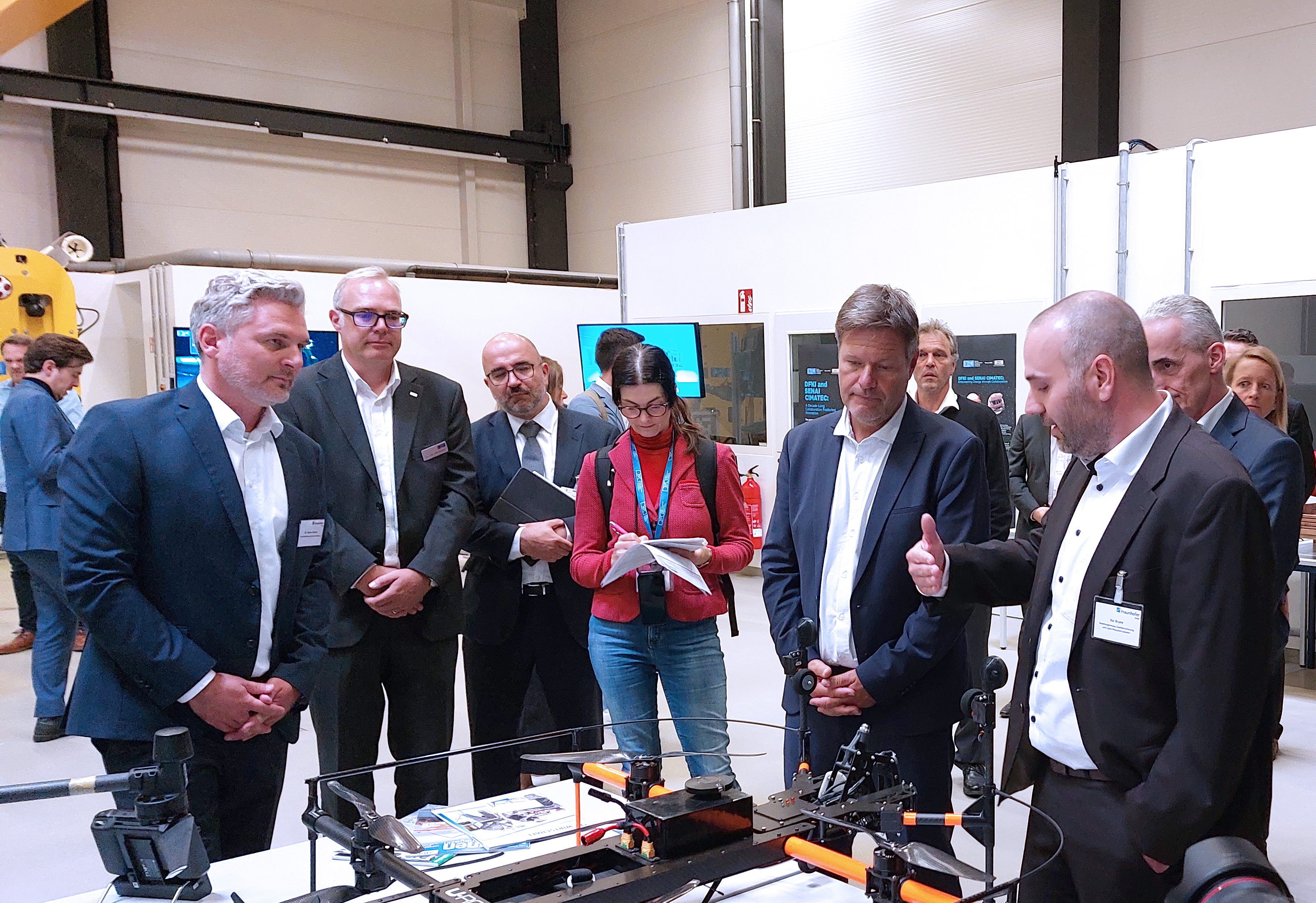 Kai Brune (re.) und Dr. Hanno Schnars (li.) erklären Dr. Robert Habeck die Potenziale von Offshore-Drohnen bei Inspektionsarbeiten an Windenergieanlagen