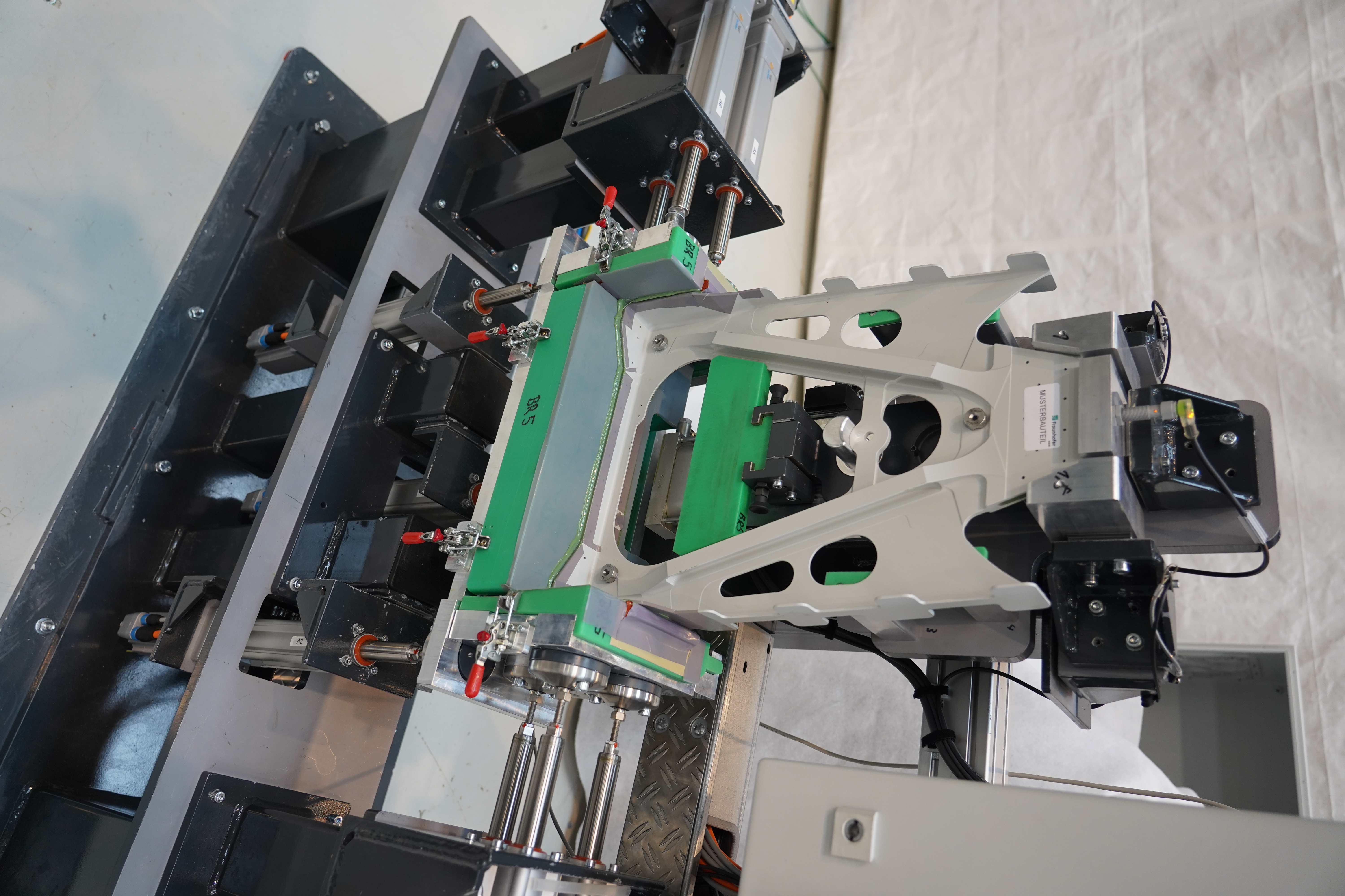 Automatisierungsstation zum Einstellen der zuvor vermessenen Hinterholmgeometrie einer Flugzeug-Seitenleitwerkbox für den Prozess-ausgelagerten Bauteiltoleranzausgleich einer Rudergabel (»Offline Shimming«). Automatisierungsstation zum Einstellen der zuvor vermessenen Hinterholmgeometrie einer Flugzeug-Seitenleitwerkbox für den Prozess-ausgelagerten Bauteiltoleranzausgleich einer Rudergabel (»Offline Shimming«).