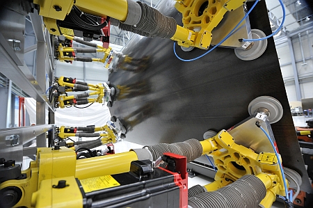 Robot and vacuum grippers shape a component. Robot and vacuum grippers shape a component.