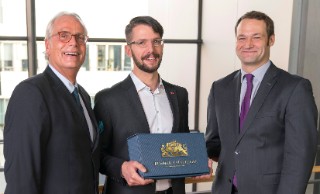 Prof. Dr. Andreas Groß (left) and Dr. Erik Meiß (right) honor Marco Molisse during the 17th Bremen Bonding Days as the ten thousandth course participant of the Training Center for Adhesive Bonding Technology.