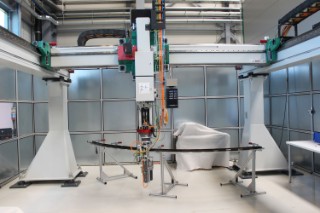 The automation environment developed by the experts for Automation and Production Technology at Fraunhofer IFAM with the portal and the connected positioning and drilling end effector as well as the frame elevation for automated positioning and drilling of the cleat on the integral frame.