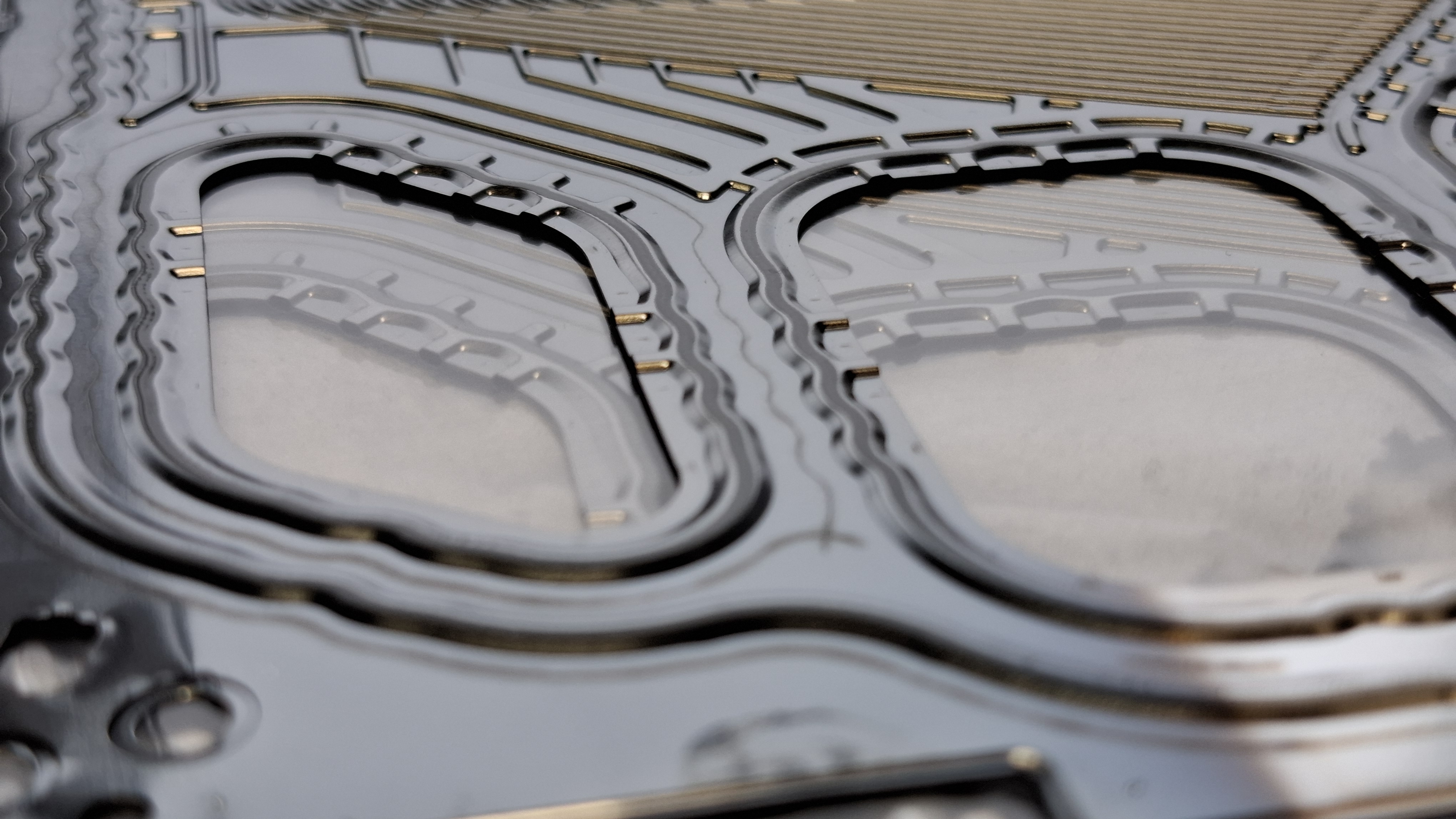 Opaque silicone gasket applied and cured at IFAM as a CIPG variant (Cure in Place Gasket) with a thickness of 60 µm and a web width of 1 mm on the embossed bead contour of the ZSW bipolar plate. Components can now be used for further tests with regard to leakage, material-free and ageing tests as well as disassembly capability after stacking and rapid climatic ageing.