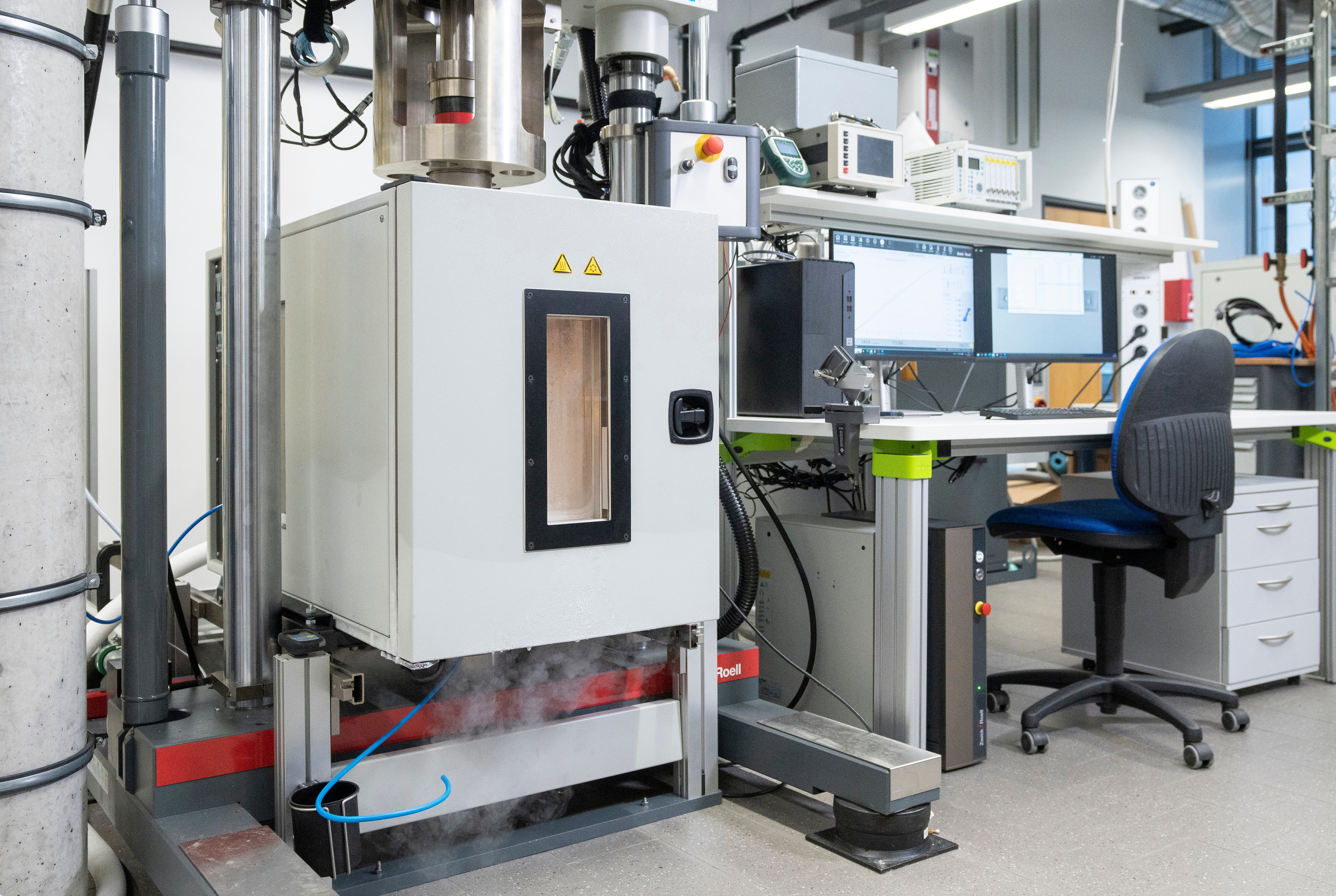 Test setup with climate chamber for material testing of polymers, adhesives, adhesive joints, and fiber composites at cryogenic temperatures as low as -170 °C.